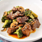 Plate of Slow Cooker Beef and Broccoli garnished with sesame seeds.