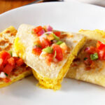 Easy Vegan Breakfast Quesadillas stacked with fresh salsa on top.