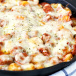 Chicken Sausage and Gnocchi Skillet next to a kitchen towel and loaf of Italian bread.