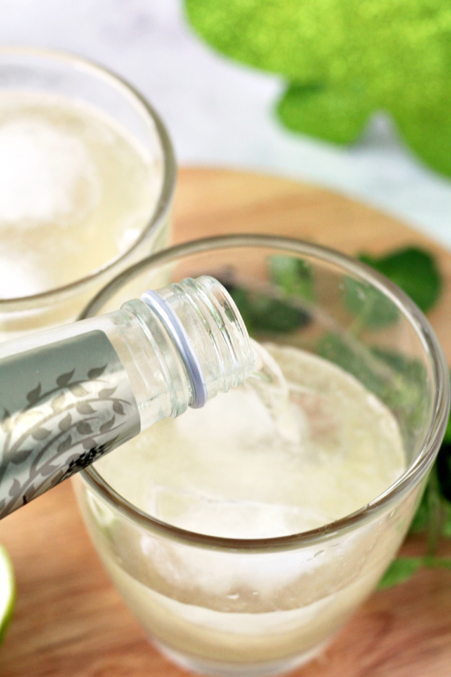 Bottle of ginger beer being poured into a cocktail glass.