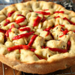 Small Batch Focaccia Bread topped with Parmesan cheese, roasted red peppers, and fresh rosemary on a wire rack.