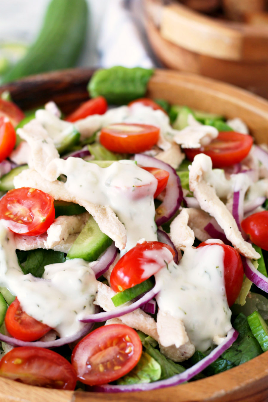 Chicken Gyro Salad topped with a generous drizzle of tzatziki sauce.