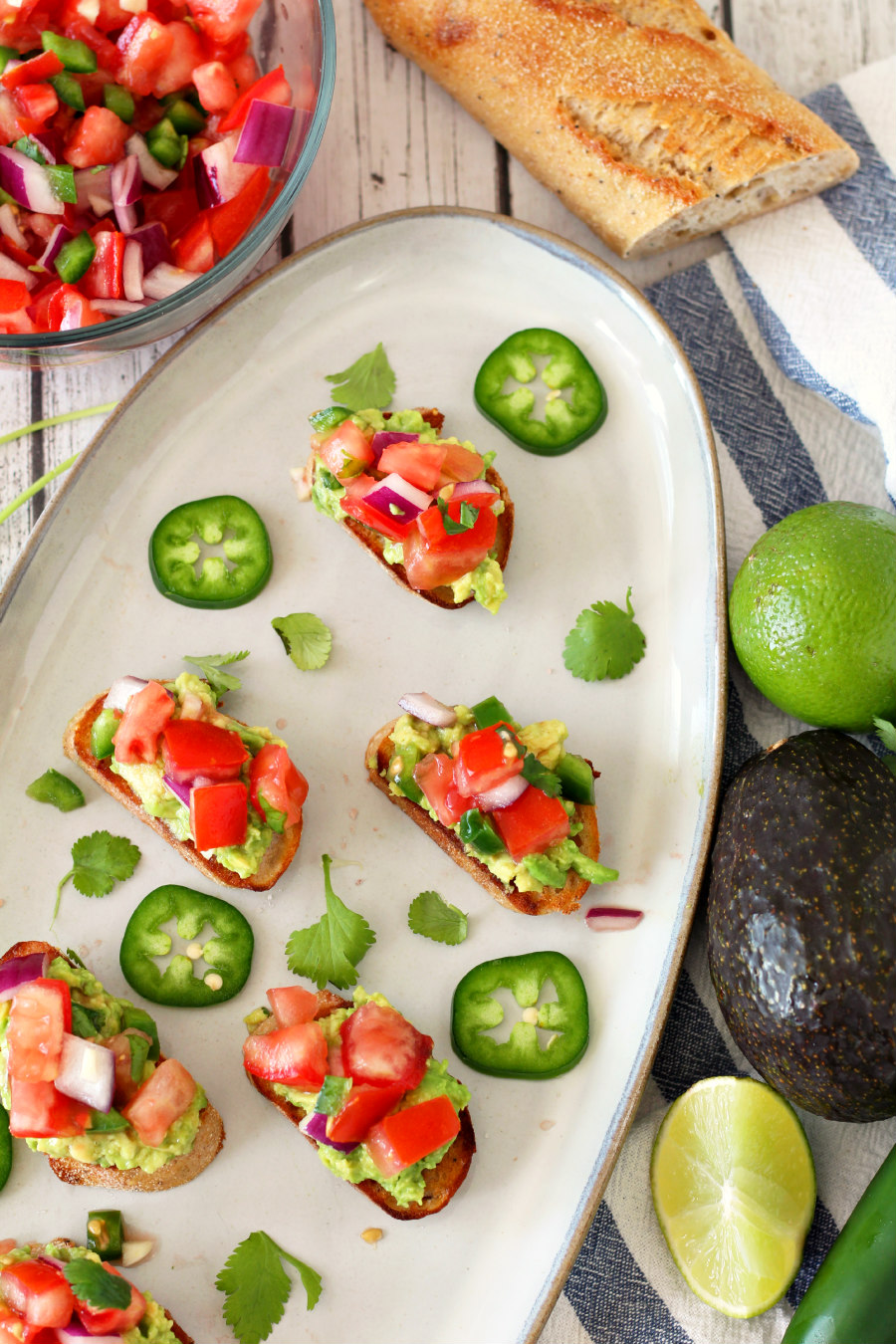 Mexican Bruschetta on a platter garnished with fresh cilantro and jalapeño slices.