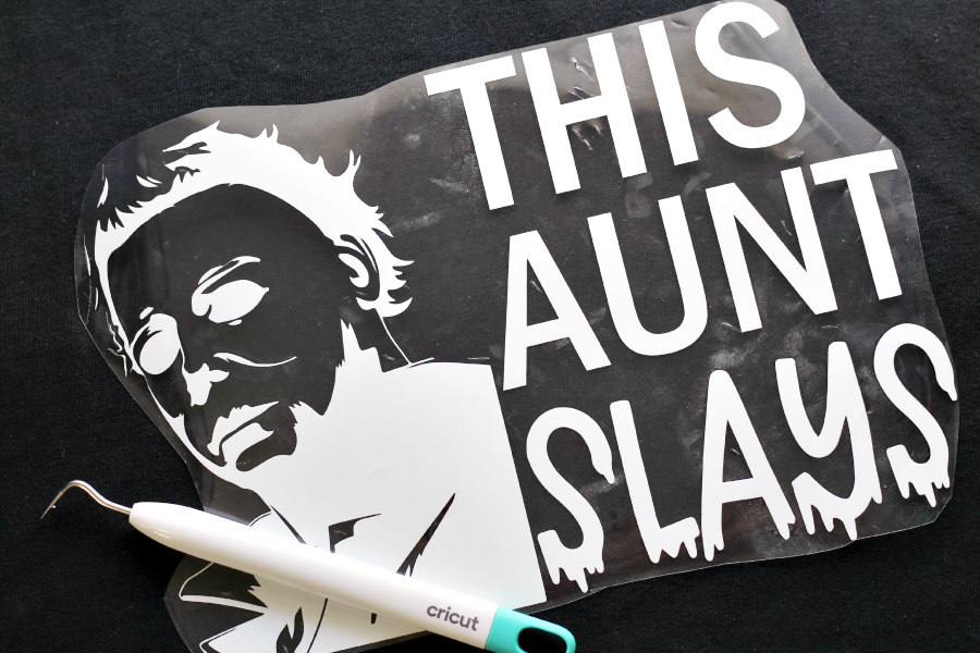 This Aunt Slays Shirt design weeded and placed on top of black t-shirt with weeding tool.