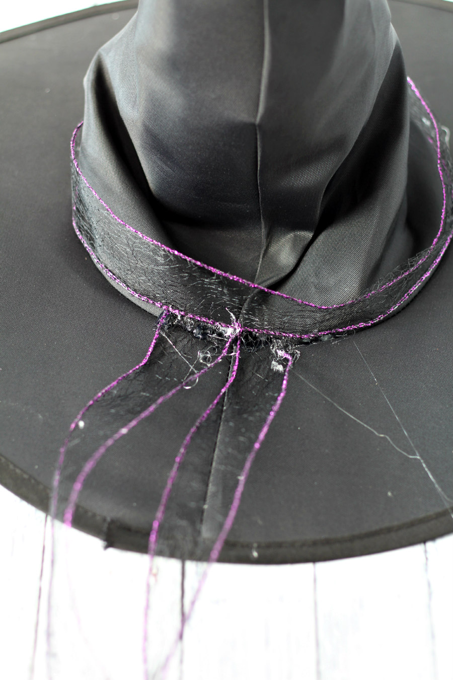 Purple trimmed black ribbon hot glued around witch hat.