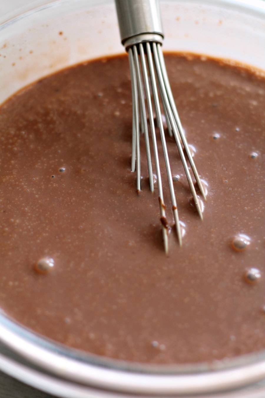 Instant chocolate pudding mixed in a bowl with a metal whisk.
