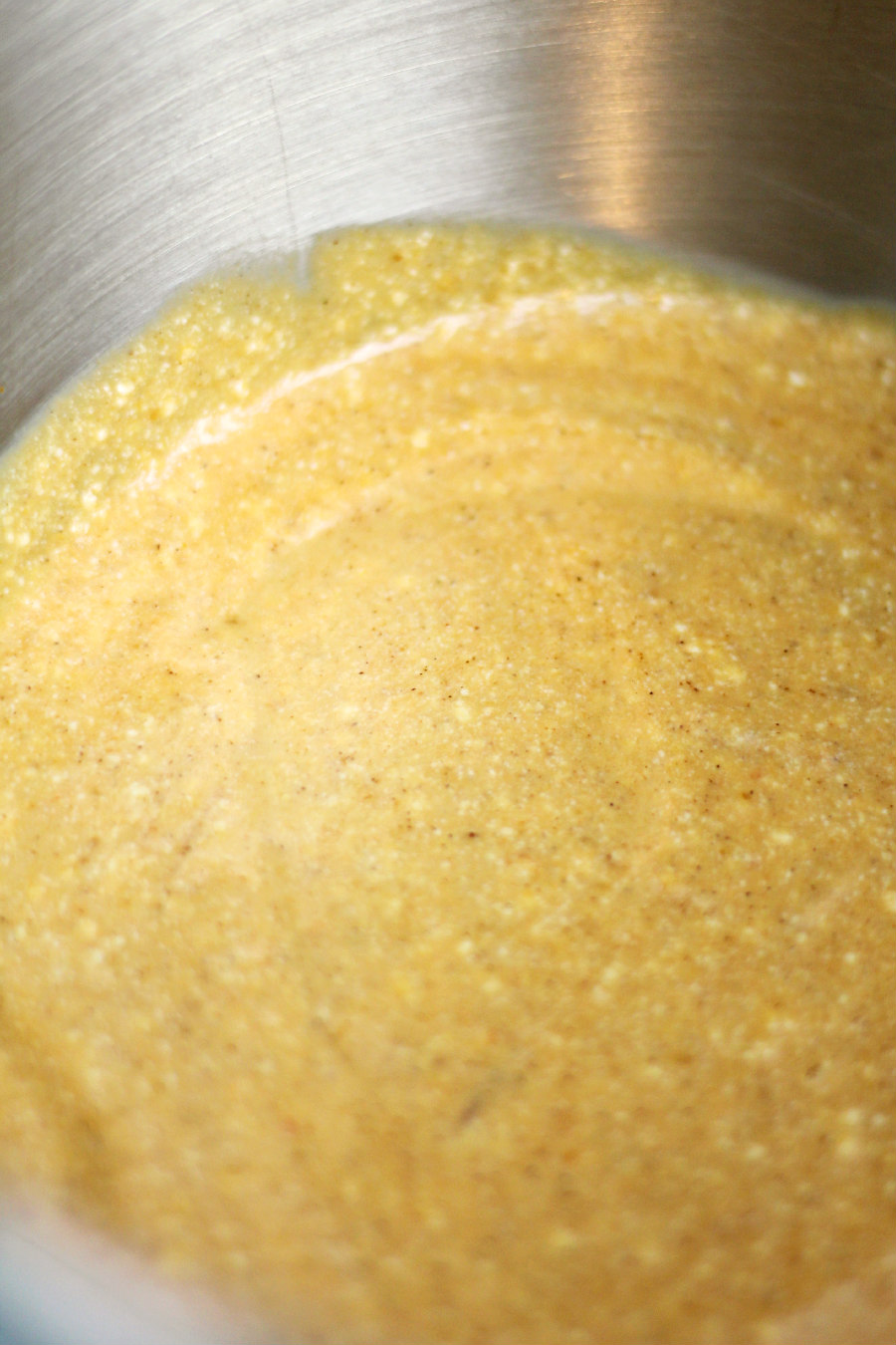 Eggs, ricotta cheese, pumpkin puree, and vanilla extract mixed together in a metal mixing bowl.