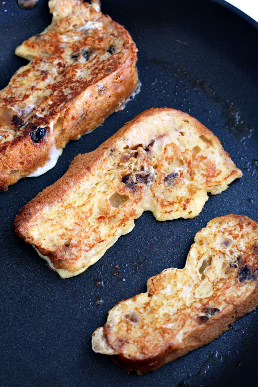 Panettone French Toast slices being cooked in a large skillet.