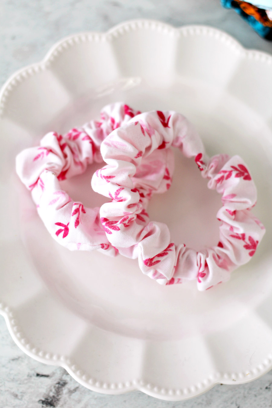 Pink Foilage Leaves Scrunchie Elastic Hair Tie from Holoka Home on Etsy. Pink scrunchie features dark pink foliage. Two scrunchies are placed on white plate.