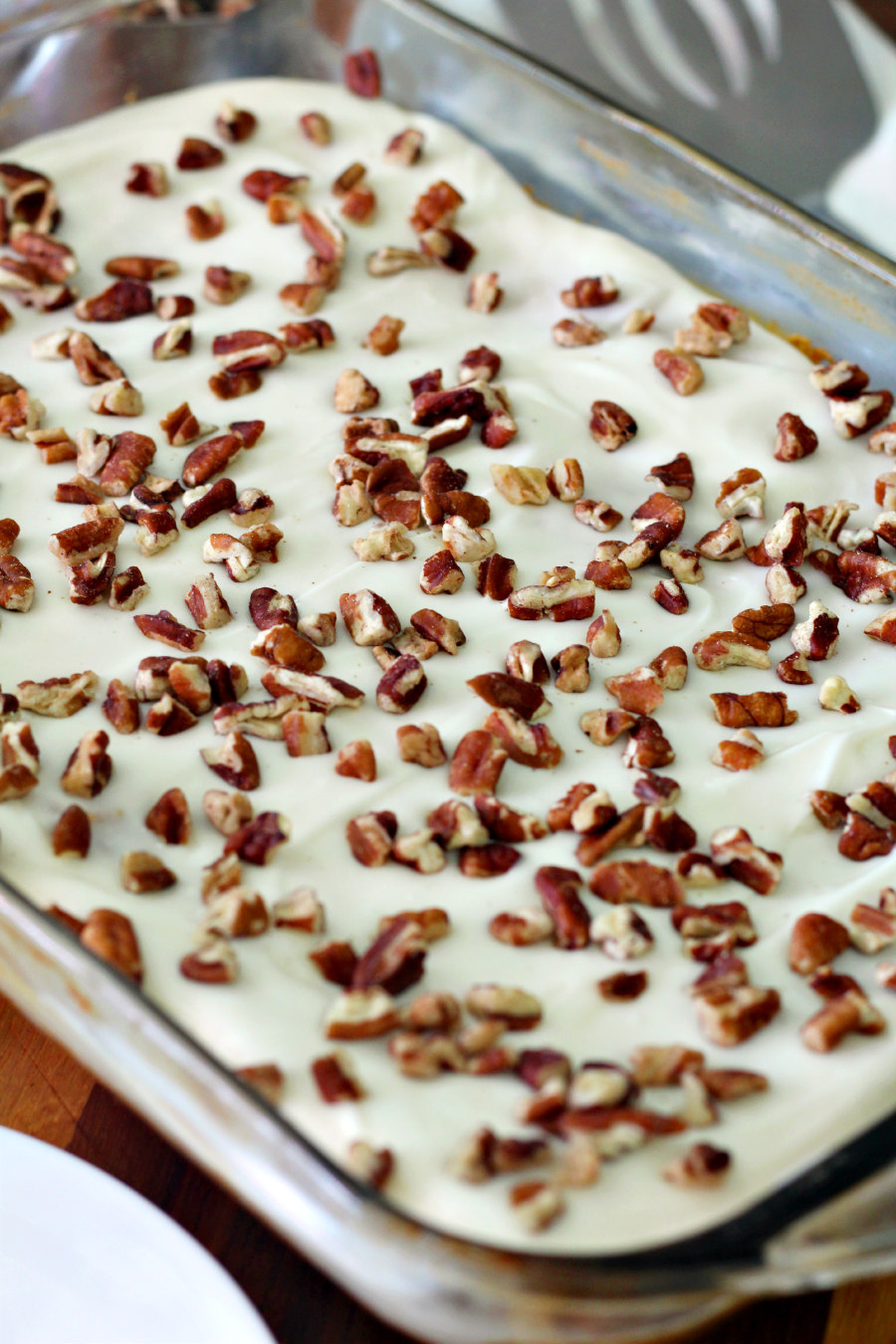 Close up photo of Hummingbird Pudding Dump Cake in baking pan. Small white plate and spatula also in photo.