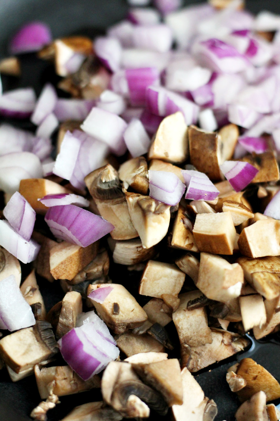 Chopped red onion and baby bella mushrooms in cast iron skillet.  