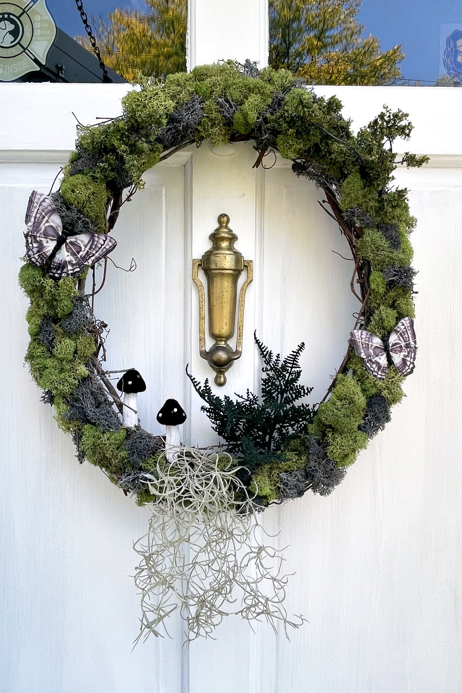Mossy Mushroom Halloween Wreath hangs on white front door.