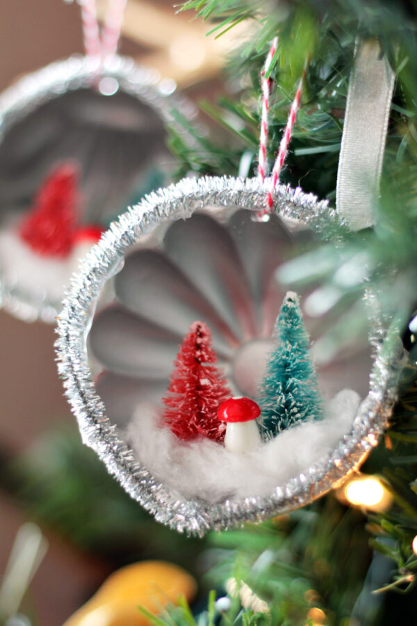 Thrifted Mini Tin Mold Ornaments hang from lit Christmas tree.